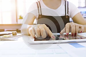 Cropped shot of Woman Touching stock market graph on a touch screen device in home. Trading on stock market concept.