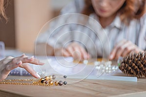 cropped shot of women making accessories of beads