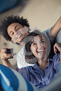 Cropped shot of a young african american couple watching television at home