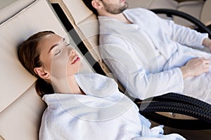 cropped shot of young couple in bathrobes resting together