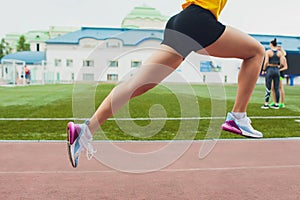 Cropped shot of young female athlete launching off the start line in a race. Female runner started the sprint from the