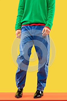 Cropped shot of young man in bright colored clothes on yellow background