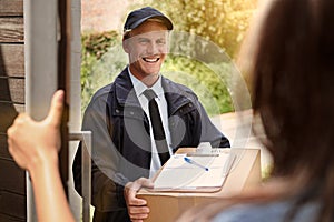 Delivering your goods with a smile. Cropped shot of a young man making a delivery to a woman at her home.