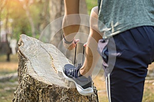 Cropped shot of young man runner tightening running shoe laces,