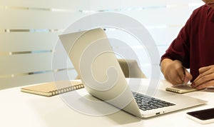 Cropped shot of a young man's hand moving while writing note wit