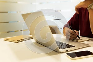 Cropped shot of a young man writing note with laptop computer, m