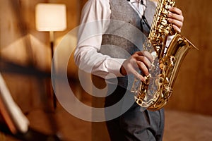 Cropped shot of young musician standing and playing saxophone