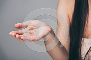 cropped shot of young woman holding fallen hair in hand