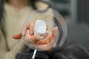 Cropped shot of young woman using a fingertip pulse oximeter to checking oxygen saturation level and pulse.