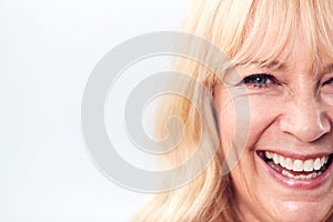 Cropped Studio Shot Of Laughing Mature Woman Against White Background At Camera