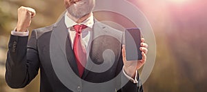 cropped successful businessman presenting product. success. presentation on smartphone. Horizontal poster design. Web