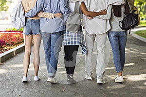 Cropped of teen friends hugging and walking by street