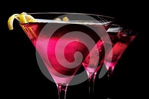 Cropped three cosmopolitan cocktails in line on black