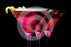 Cropped three cosmopolitan cocktails in line on black background