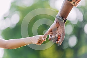 cropped view of african american grandfather holding hands