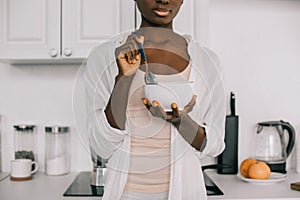 Cropped view of african american woman holding spoon and bowl with cornflakes