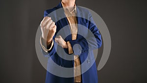 Cropped view of aggressive business woman, leader or bossy manager showing fist. Gray background with space for text.