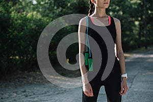 cropped view of athletic girl with jump rope