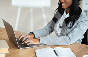 Cropped view of black business lady typing on laptop keyboard at office, closeup