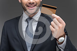 cropped view of businessman holding golden credit card