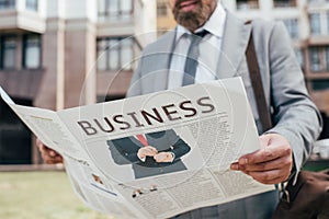 cropped view of businessman reading business newspaper