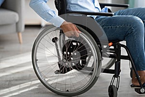 Cropped view of disabled black man sitting in wheelchair at home. Impairment and mobility aids concept