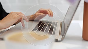 Cropped view female hands typing laptop keyboard on cafeteria table. Unrecognisable businesswoman worker entrepreneur