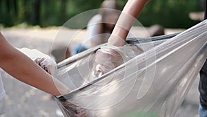 Cropped view of garbage bag in process of colecting litter