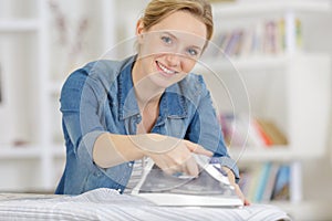 cropped view girl ironing white pants at home