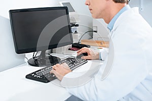 cropped view of male optician working with computer