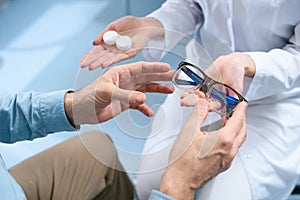 cropped view of man choosing eyeglasses or contact lenses