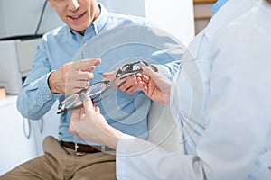 cropped view of man choosing glasses