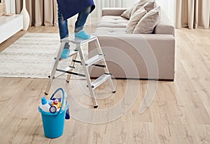 Cropped view of man climbing ladder to clean ceiling. Cleaning service concept