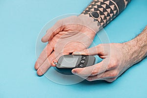 Cropped view of man doing glucose level test with glucometer