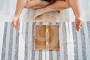 Cropped view of Man exercising yoga meditating and sitting on the floor near sadhu board