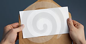 Cropped view of man holding craft envelope with blank white card