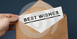 Cropped view of man holding craft envelope with text BEST WISHES