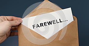 Cropped view of man holding craft envelope with text FAREWELL