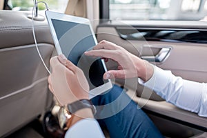 cropped view of man using digital tablet on backseat