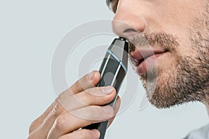 cropped view of man using electric trimmer for nose