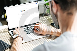 cropped view of man using laptop with google website