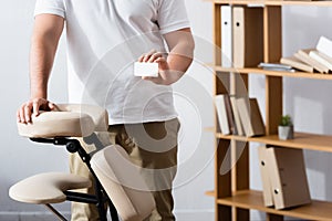 Cropped view of masseur standing near photo