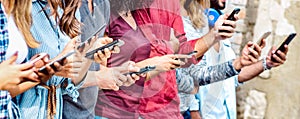 Cropped view on millenial hands using mobile smart phones - People addicted by smartphones - Technology concept photo