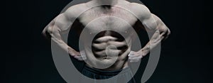 cropped view of muscular bodybuilder with abs in studio. strong bodybuilder has muscular torso