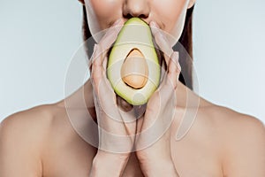 cropped view of naked girl posing with natural avocado