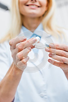 cropped view of optician in white coat holding