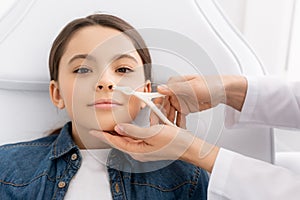 Cropped view of otolaryngologist examining nose