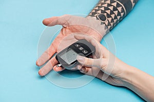 Cropped view of people hands with glucometer