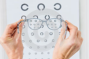 cropped view of person holding glasses with eye