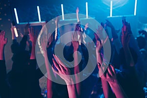 Cropped view photo blurred of large group people raise hands enjoy disco discotheque dance floor